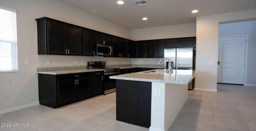 Open kitchen concept. Well-lit kitchen with a built in SS microwave.