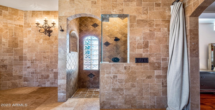 Walk in shower with double shower heads and bench.