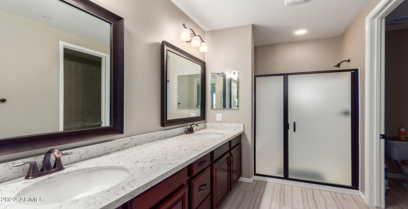 Lovely primary bath with dual sinks, bronzed finishes and walk in shower!