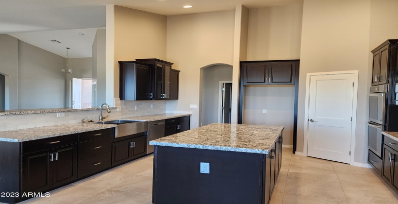 ACTUAL PICTURE OF KITCHEN WITH UPGRADED ESPRESSO STAINED CABINETS, LARGE ISLAND AND GRANITE COUNTERS