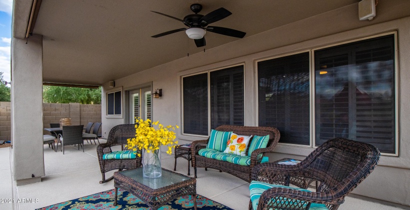 SITTING AREA UNDER COVERED PATIO AND LARGE DINING OUTDOOR TABLE