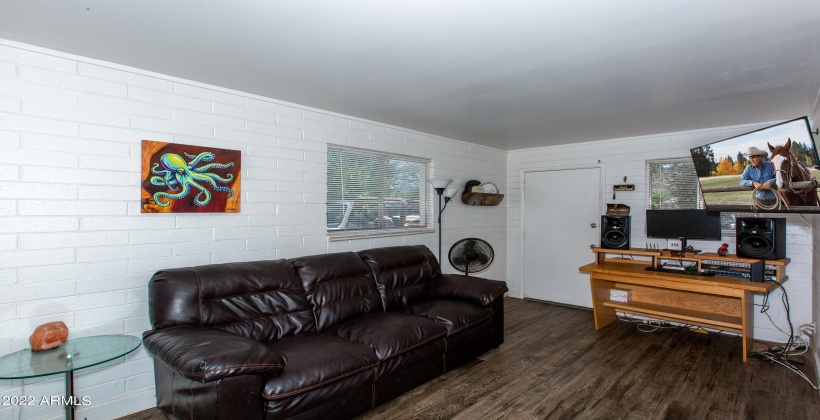 Unit #2, light and bright living room with two windows. All window covering stays.