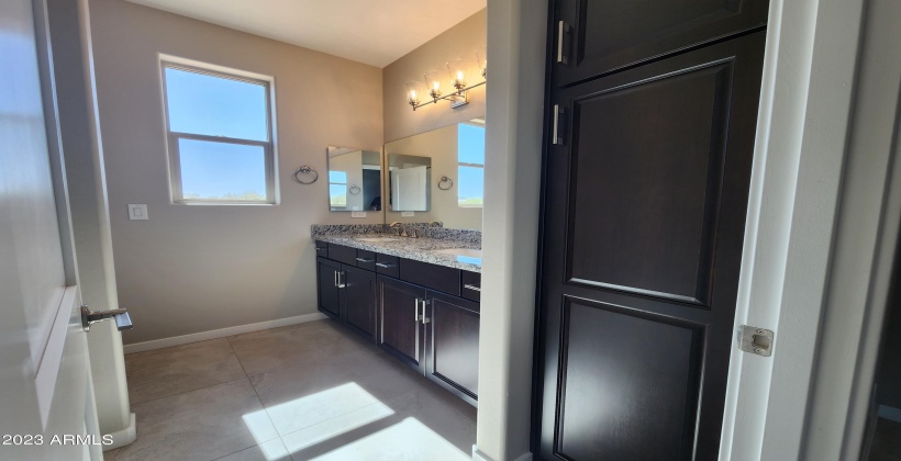 ACTUAL PICTURE OF THE HALL BATH WITH DUAL SINKS, LINEN CABINET AND GRANITE COUNTER TOP