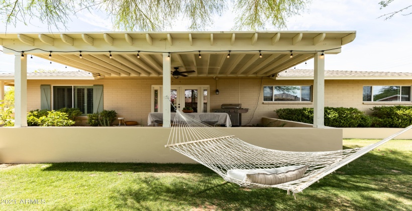 Side patio with hammock, outdoor dining and grill.