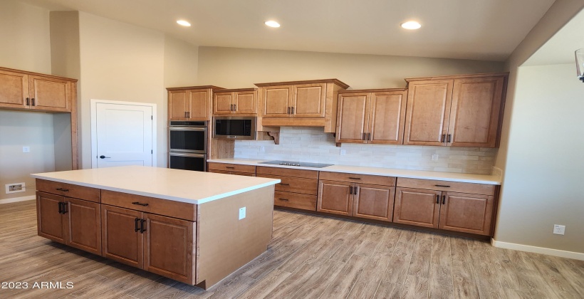 ACTUAL PICTURE OF THE KITCHEN WITH LARGE ISLAND, AND UPGRAGED CABINETS, DOUBLE WALL OVENS, BUILT IN MICROWAVE, 36 INCH COOKTOP WITH BUILT IN EXHAUST CABINET, GRANITE COUNTERS