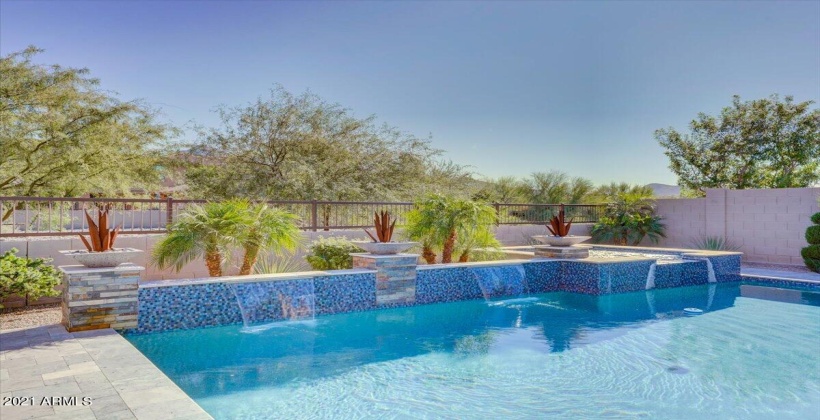 Swimming pool with water fountains and elevated spa