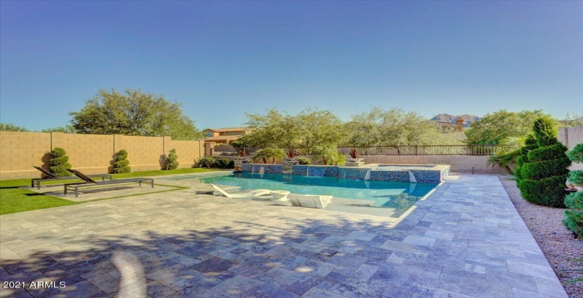 Swimming pool with water fountains and elevated spa