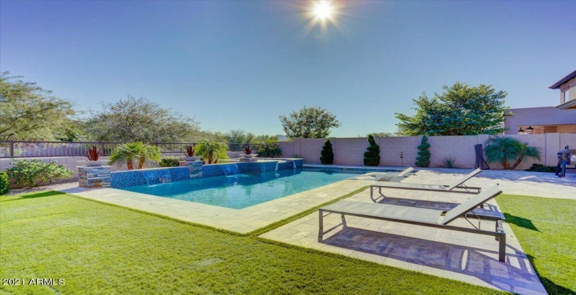 Swimming pool with water fountains and elevated spa