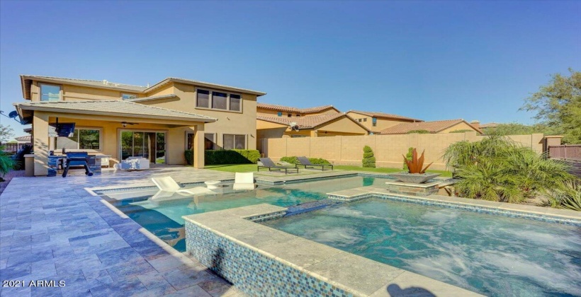 Swimming pool with water fountains and elevated spa