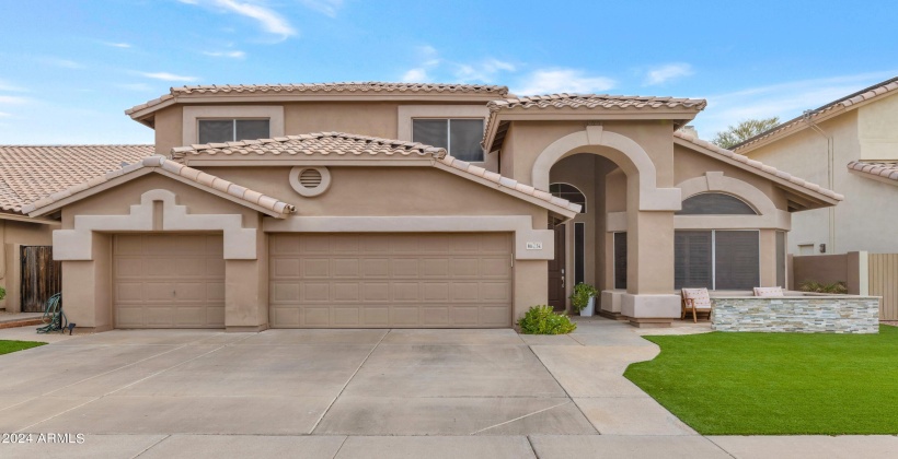 Lush artificial turf front yard with tiled front courtyard.