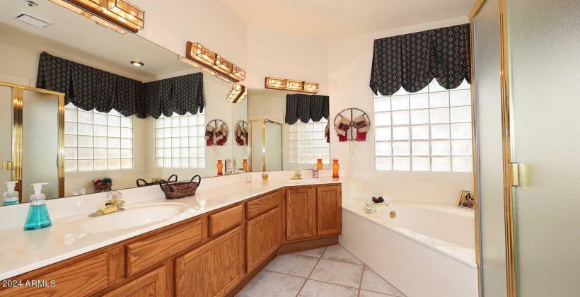 Spacious vanities with double sinks, soaking tub plus shower, private toilet area, glass block for bright and cheerful mornings and walk-in closet