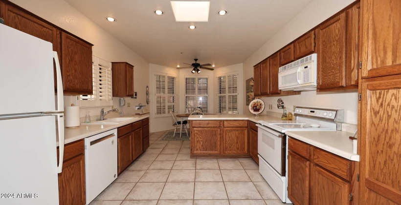 White shutters at front of home with appliances, breakfast bar and pantry.