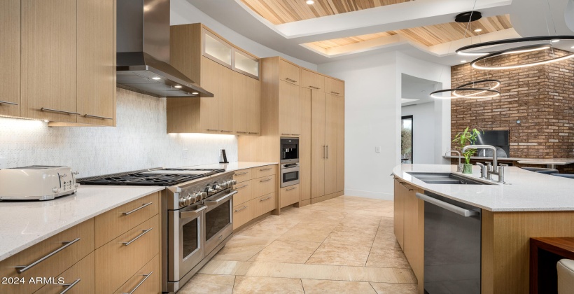 Fully Equipped Modern Kitchen featuring Stainless-Steel Appliances, Breakfast Bar Island and Informal Dining Area.