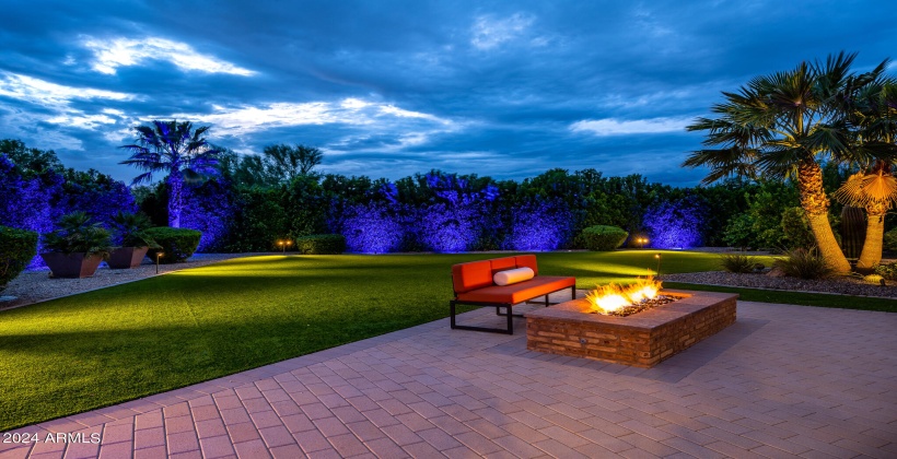 STUNNING Resort-Like Backyard featuring covered patio with outdoor furniture, BBQ grill, sparkling blue pool and spa, sun loungers, firepit, putting green, and ample yard space.