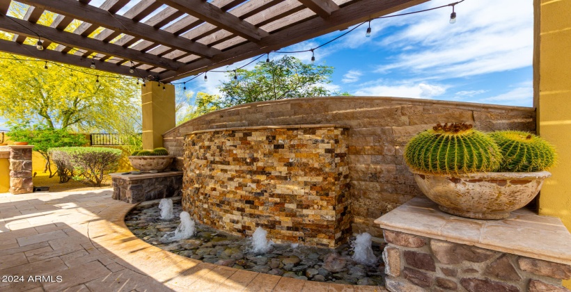 Outdoor waterfall feature under the pergola