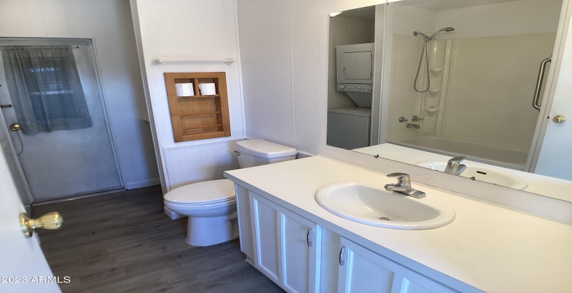 Roomy bathroom with extra storage, stacked washer and dryer, and easy access to the shed.