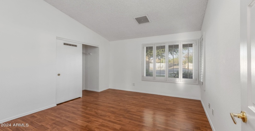 Valulted ceilings, dual pane window and charming shutters in this east facing bedroom